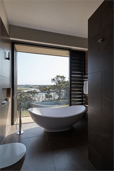 Large picture window and louvre window brighten this luxurious bathroom