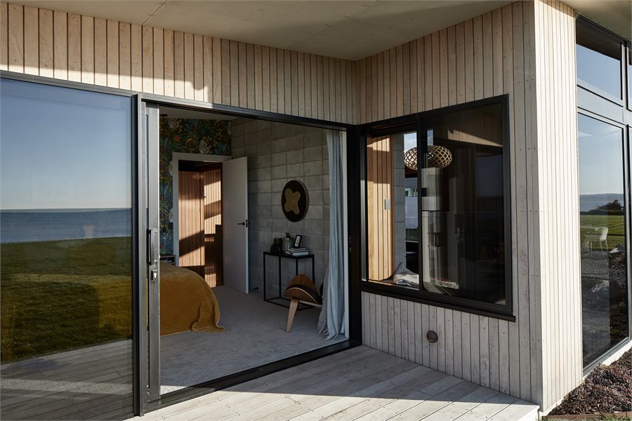 The morning sun streams into the master bedroom through the Residential Series sliding door. The sliding window in the living room creates a reading nook with a view.