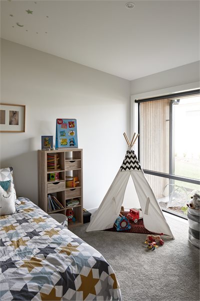 A large fixed window to brighten the bedroom is teamed up with a bank of timber louvres to the right (not shown) for ventilation.