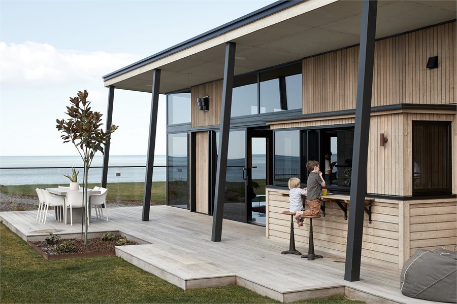 The windows and large sliding stacking doors open the home up right along the northern side creating an outdoor space that feels like an extension of the living area.