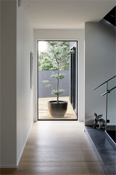 Passages linking the communal and quieter areas of the home feature Metro Series picture windows that reveal the Japanese-inspired planting surrounding the home