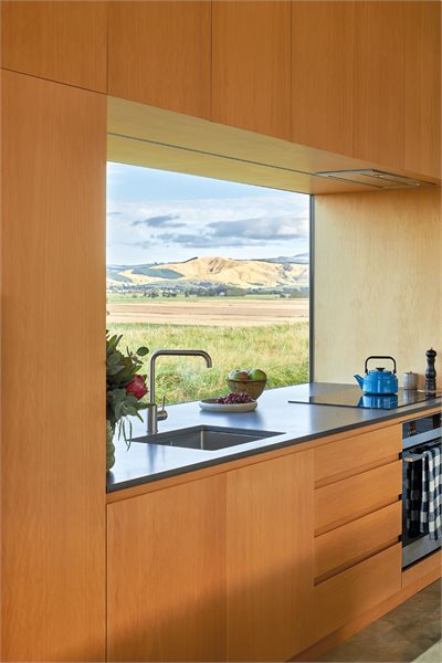 A large custom window centers the view as a kitchen splashback